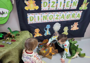 chłopcy bawią się dinozaurami