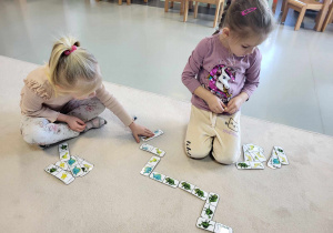 dziewczynki grają w dinozaurowe domino