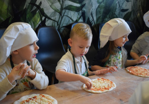 dzieci sypią ser na pizzę