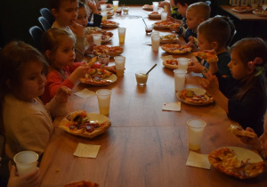 dzieci konsumują pizzę