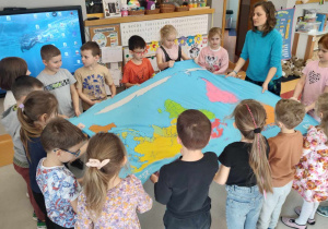 dzieci rozkładają mapę świata