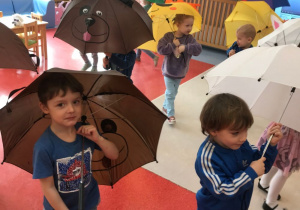 Dzieci bawią się z parasolami