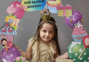 Dziewczynka pozuje w fotobudce urodzinowej