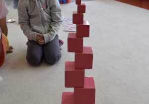 dziewczynka układa różową wieżę