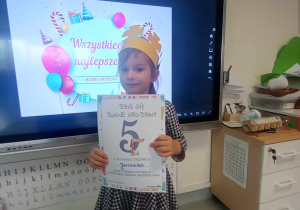 dziewczynka trzyma urodzinowy dyplom