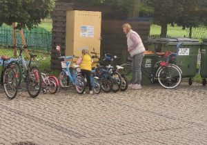 dziewczynka z mamą parkuje rower