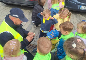 dzieci stoja wokól Pana policjanta