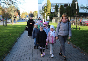 dzieci z paniami idą do teatru