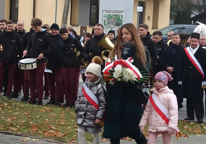 pani dyrektor wraz z dziećmi podczas Gminnej Uroczystości składa kwiaty