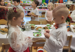 dzieci składają sobie życzenia i dzielą się opłatkiem