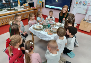 przedszkolaki siedzą wokół przygotowanego stołu