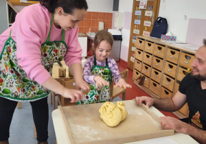 dziewczynka z panią Justyną ugniatają ciasto