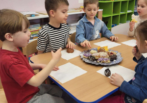 Dzieci jedzą pączki