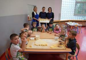 pamiątkowe zdjęcie grupy 5 latków z paniami kucharkami i uformowanym ciastem