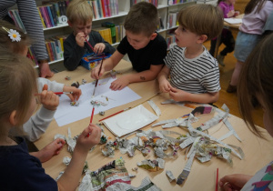 dzieci przyklejają kulki z gazet