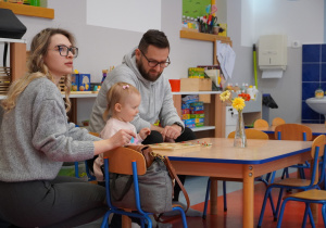 dziewczynka z rodzicami układa puzzle