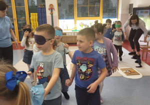 dzieci próbują samodzielnie iść z zasłoniętymi oczyma