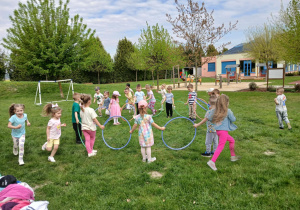 Przedszkolaki przechodzą przez hula-hop