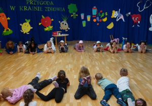 Dzieci i aktorki leżą na podłodze