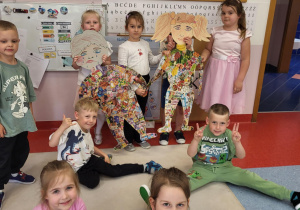 Dziewczynka i chłopiec przedstawiające zdrowe i niezdrowe produkty