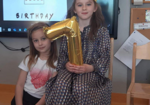 dziewczynka trzyma cyfrę siedem