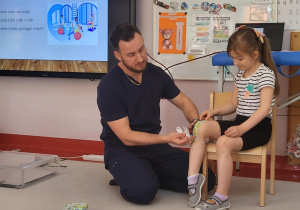 fizjoterapeuta przykleja plaster Julii