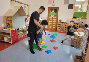 chłopiec z pomocą fizjoterapeuty chodzi po ścieżce sensorycznej