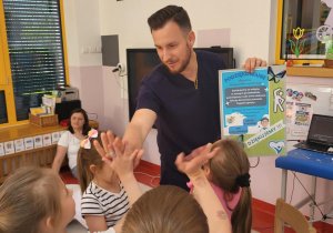 pan Daniel żegna się z dziećmi i prezentuje laurkę z podziękowaniami od dzieci