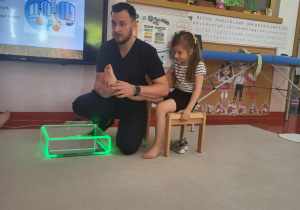 pan fizjoterapeuta pokazuje stopę Julii