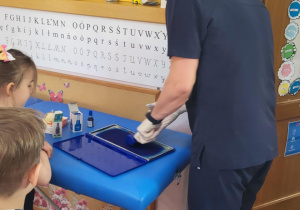 pan Daniel przygotowuje się do odcisków stóp dzieci