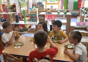 Dzieci przy stolikach przy poczęstunku