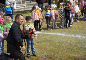 dziecko leje wężem strażackim