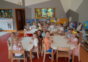dzieci jedzą deserki i pokazują kciuki
