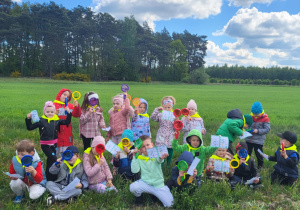 Dzieci pozują na łące z lupami