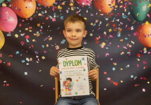 Chłopiec pozuje z dyplomem