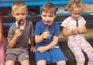 Dzieci jedzą lody na tarasie