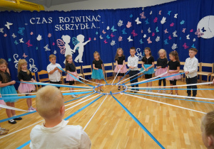 dzieci trzymają wstążki
