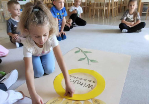 Dziewczynka przykleja płatek ze swoim imieniem