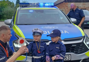 Małe policjantki przy radiowozie
