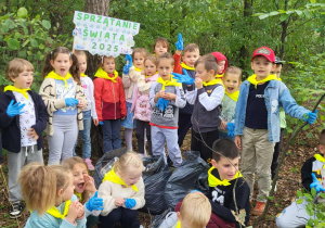 Grupowe zdjęcie z transparentem w lesie