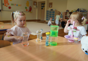 dziewczynka patrzy na klepsydry