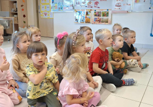 dzieci siedza i słuchają