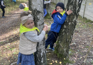 Dzieci przytulają drzewo