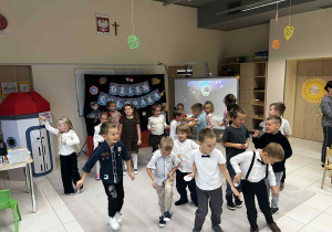 Dzieci tańczą na dywanie