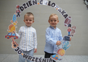 chłopcy trzymają napis i obrazki