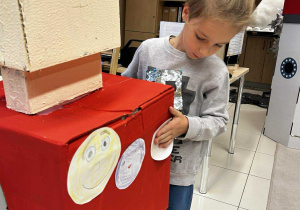 Chłopiec ozdabia robota