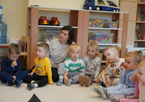 dzieci siedzą na dywanie