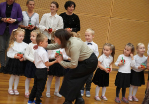 dziecko wręcza jabłko pani