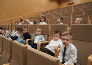 dzieci siedzą na widowni