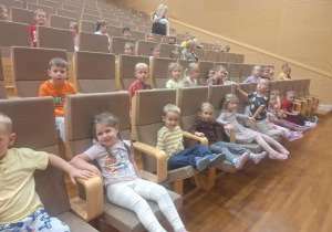 dzieci siedzą oglądając koncert